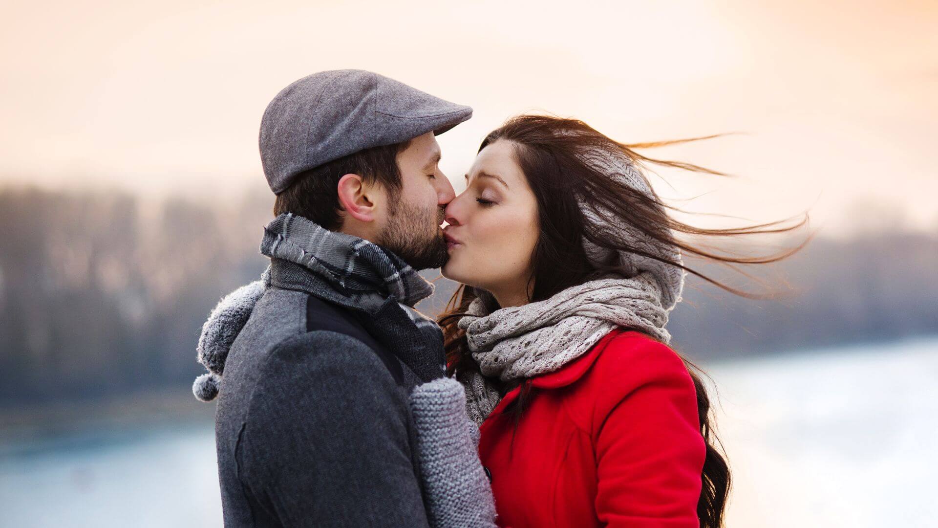 a couple kissing in a wintry backdrop