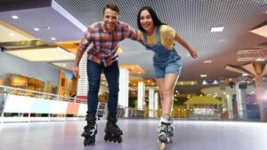 a romantic couple rollerskating at an indoor rink